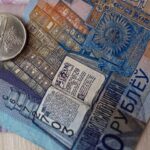 Белорусские деньги в виде двух купюр и монеты лежат на столе