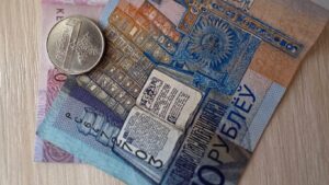Белорусские деньги в виде двух купюр и монеты лежат на столе
